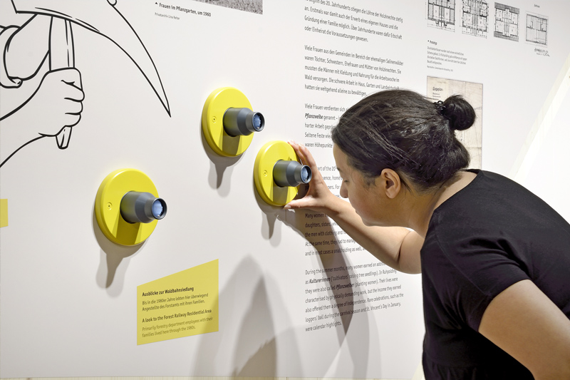 Frau erkundet interaktive Station in Dauerausstellung des Holzknechtmuseums Ruhpolding