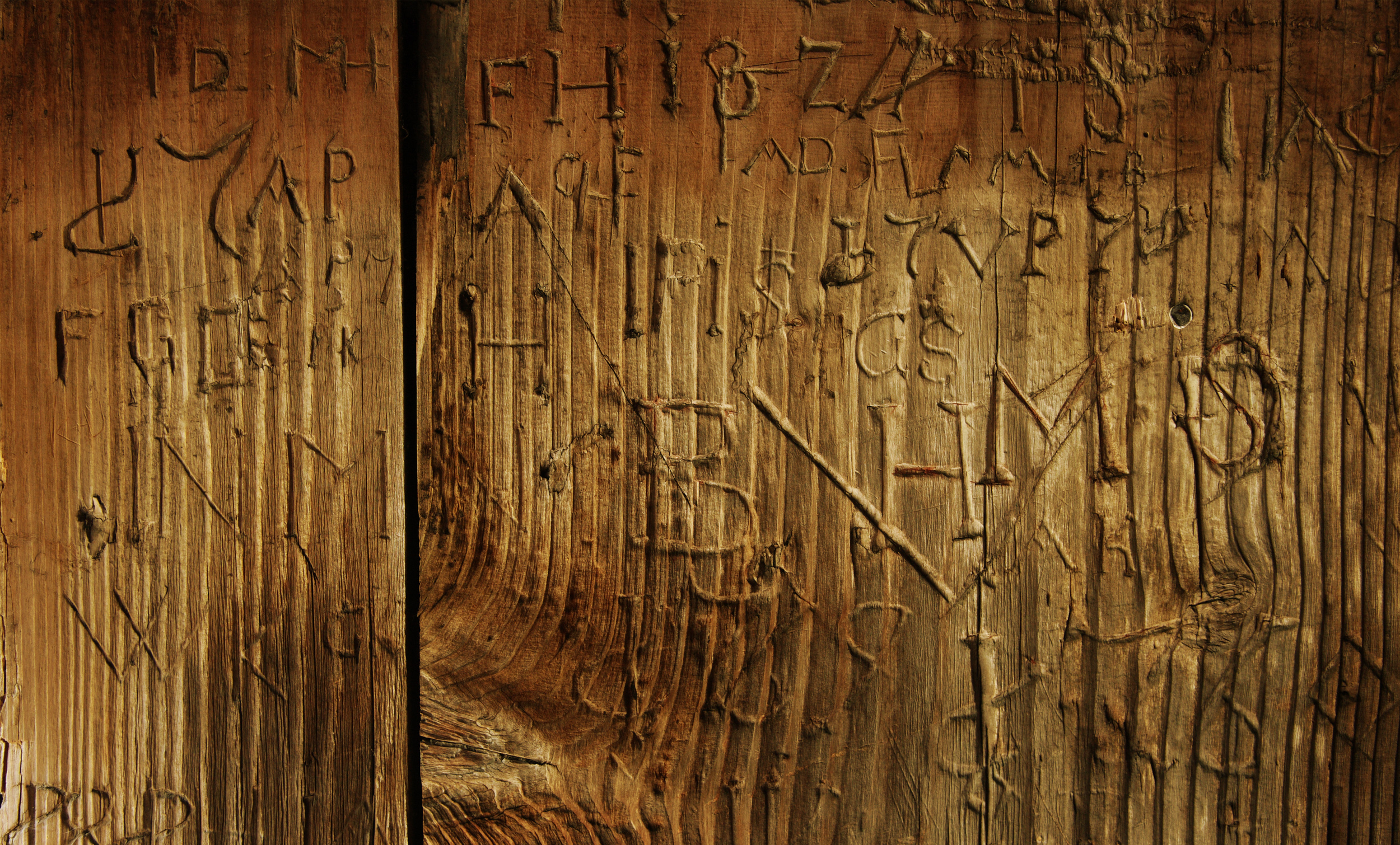 Nahaufnahme von in Holz geritzten Schriftzeichen